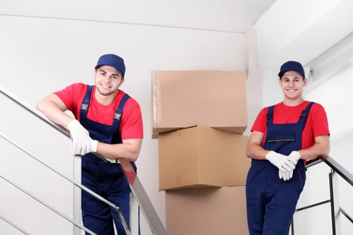 Movers carrying items through a Hounslow flat building